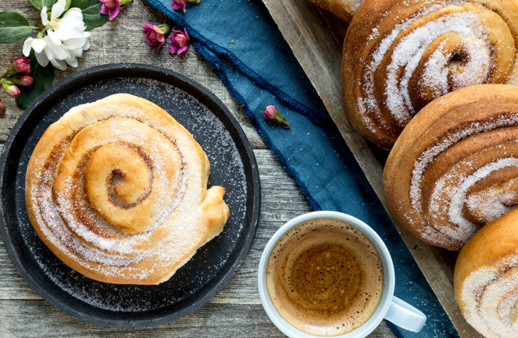 Skillingsbolle og kaffe fra baker brun som har bakeriutslag på Marineholmen. Fristende dekket på med fine blomster rundt.